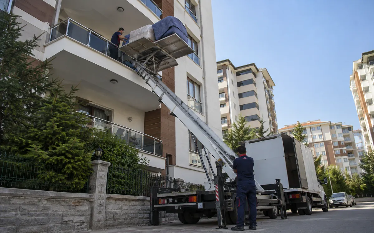 Dış cephe asansörü ile apartmanın üst katından eşya indiriliyor